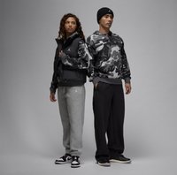 Sort ærmeløs puffer vest, grå camouflagesweatshirt, grå sweatpants, sort hue, sort og hvid sneakers. Afslappet atletisk påklædning.
