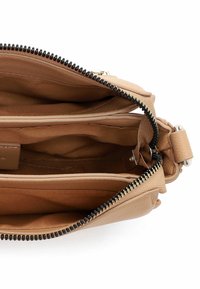Beige Lederhandtasche Innenraum mit zwei Fächern, hellbraunem Stofffutter und schwarzen Reißverschlussdetails.
