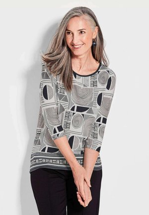 Dreiviertelarm-Shirt mit geometrischen Schwarz- und Creme-Mustern, Rundhalsausschnitt und lässiger Passform.
