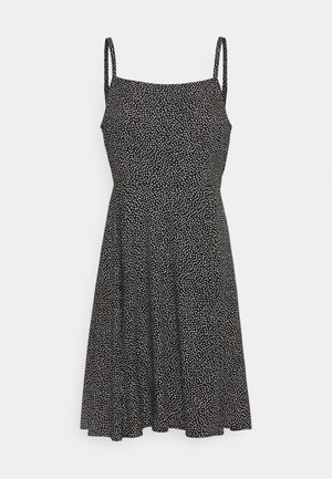 Robe noire sans manches à pois blancs, encolure carrée, taille ajustée et jupe évasée.