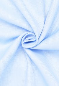 Tessuto di colore azzurro chiaro con texture, che mostra un fine motivo intrecciato, disposto a spirale per la presentazione. La lieve lucentezza mette in risalto la superficie liscia e la leggerezza del materiale.