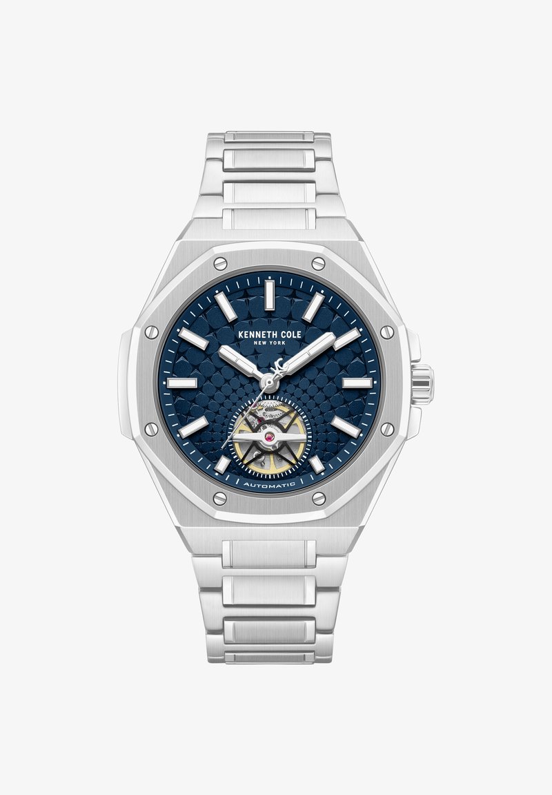 Reloj automático Kenneth Cole con esfera azul texturizada, marcadores de hora plateados, caja hexagonal plateada y pulsera de eslabones de acero inoxidable.