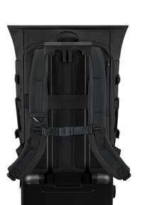 Zaino nero con spallacci imbottiti e schienale in rete, dotato di un design arrotolabile e di una maniglia integrata per essere attaccato ai bagagli.