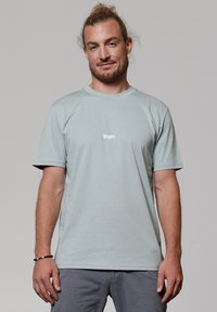 Lichtblauw katoenen T-shirt met korte mouwen, voorzien van de tekst "Nope." in het wit. Eenvoudig ontwerp, ronde halslijn, ontspannen pasvorm.