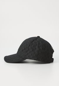 Casquette de baseball noire avec un motif texturé comportant des formes de diamant répétées. Visière et sangle réglable en tissu assorti.
