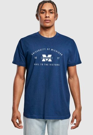 Námořnická modrá bavlněná tričko s textem "University of Michigan" a bílým logem "M", s uvolněným střihem a krátkými rukávy.