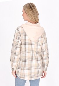 Överdimensionerad rutig skjorta i kräm- och beigetoner med en lätt rosa hoodie. Tyg i bomullsblandning, knappade manschetter och rundad nederkant.