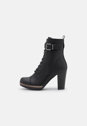 Bottine noire à talon haut avec lacets sur le devant, bride latérale à boucle, bout arrondi et semelle texturée pour une bonne adhérence.