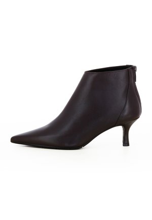 Zwarte leren enkellaars met puntige neus, slanke kitten heel en rits aan de achterkant, getoond op een witte achtergrond.
