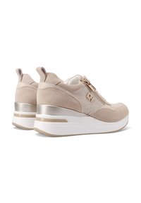 Sneakers beige con upper in suede, dettagli metallici e cerniera laterale. Presentano una suola piatta bianca con una finitura leggermente strutturata.