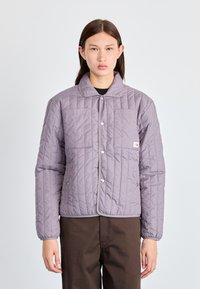 Μωβ μπουφάν με καπιτονέ ύφασμα, στρογγυλεμένο γιακά, στερεώσεις με κουμπιά και δύο τσέπες μπροστά. Ομαλή υφή με ελαφριά σιλουέτα.