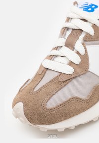 Bruna mocka- och nät-sneakers med vita snören, med en texturerad ovandel och vita accenter. Har en rundad sula med bra grepp.