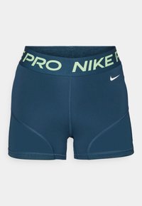 Shorts de sport bleu marine avec une large ceinture Nike Pro vert clair, des coutures divisées et un petit logo Nike blanc à l'avant.