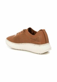 Sneaker in pelle marrone con design perforato, suola rigata bianca e chiusura con lacci. Presenta una texture liscia e una forma arrotondata.