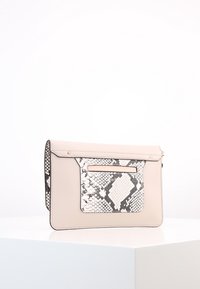 Bolso de mano de cuero beige con un bolsillo de impresión de pitón en blanco y negro texturizado, que cuenta con una tira horizontal de hardware en la parte frontal.