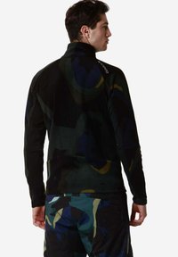 Giacca in pile nera con motivi astratti multicolori. Collo alto, maniche lunghe e vestibilità aderente. Tessuto resistente con una consistenza morbida.