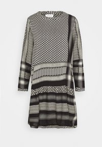 Schwarz-weißes Kleid mit langen Ärmeln, das verschiedene geometrische Muster, einen runden Ausschnitt und eine locker sitzende Passform mit ausgestelltem Saum aufweist.