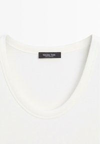Weißes, geripptes Stoffoberteil mit rundem Ausschnitt und einem schwarzen Etikett, auf dem "Massimo Dutti Made in Portugal" steht, das im Kragen eingenäht ist.