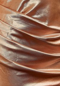 Zachte, glanzende bronzen satijnen stof met zachte plooien en lichtreflecties die een gestructureerd, glanzend oppervlak creëren.