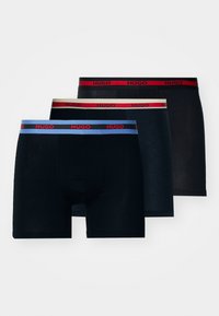 Boxer shorts noirs avec des ceintures élastiques de marque. Une paire présente une bande contrastante bleue, une autre rouge, et une troisième beige neutre.