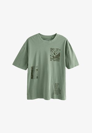 Camiseta de algodón verde oliva de manga corta, con diversos elementos gráficos en un verde más oscuro, que incluyen nombres de ciudades y un logotipo cuadrado.