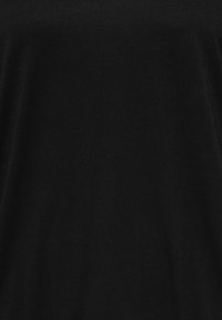 Μαύρο ύφασμα με απαλή υφή, που εμφανίζει διακριτικές σκιές και ελαφριές φυσικές πτυχώσεις.