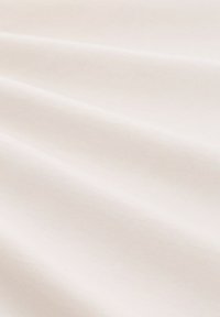 Katoenstof in een gladde, off-white kleur met een zachte textuur en subtiele glans, met zachte plooien en draperingen.