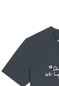 Dunkelgraues T-Shirt mit kurzen Ärmeln, auf dem in weißer Handschrift teilweise der Text "ist her" auf der Vorderseite zu sehen ist.