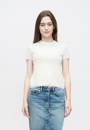 Lysegrå t-skjorte med korte ermer laget av mykt stoff, kombinert med en blå denimskjørt til knelengde med knappelukking foran.