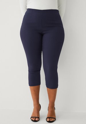 Navy blue capri pants made of stretchy material, featuring a high waist and ankle-length cut, paired with black open-toe heels.