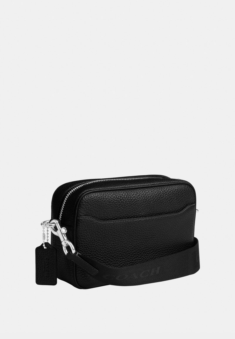 Schwarze Crossbody-Tasche aus strukturiertem Leder mit silbernem Reißverschluss und Hardware, flacher Fronttasche und abnehmbarem Riemen mit eingeprägtem Markenschriftzug.