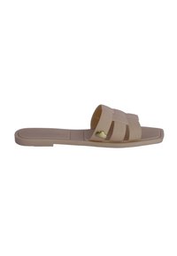 Sandalia plana beige con diseño de tira trenzada, hecha de un material flexible. Presenta un pequeño acento en forma de corazón dorado en el costado.