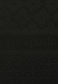 Mustassa kankaassa on teksturoitu kuvio, jossa on hillitty logo painettuna, luoden tyylikkään ja modernin ilmeen.