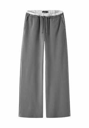 Pantalon gris à jambes larges avec ceinture élastique et cordon, avec poches latérales et doublure intérieure blanche à la taille.