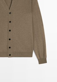 Brauner Wollcardigan mit V-Ausschnitt, langen Ärmeln und sechs schwarzen Knöpfen auf der Vorderseite. Gerippte Bündchen und Saum. Weicher, strukturierter Stoff.