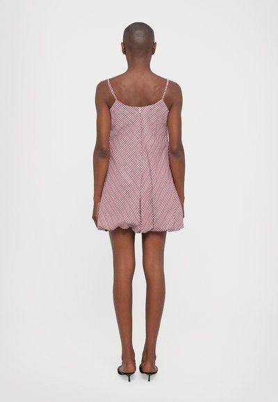 Κόκκινο και λευκό ριγέ μίνι φόρεμα με λεπτές τιράντες και φουσκωτό σχέδιο. Απαλή ύφανση με διακριτική λάμψη και μινιμαλιστικές λεπτομέρειες.