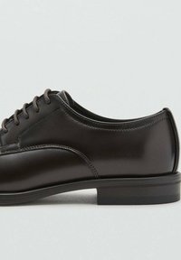 Schwarze Lederschuhe mit glatter Oberfläche, runde Spitze, Schnürdesign und minimalen Nähten. Verfügt über eine niedrige Gummisohle mit geringem Kontrast.