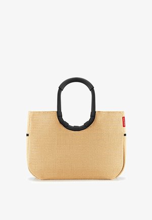 Beige woven tote bag with a rounded black handle, featuring a smooth texture and minimalist design, highlighted by a red brand tag.