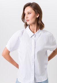 Witte kortegem sleeve shirt met een klassieke kraag, voorzien van een knoopsluiting aan de voorkant en een gladde, licht gestructureerde stof.