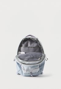 Φωτεινό γαλάζιο συμπαγές σακίδιο με ανοιχτό κύριο διαμέρισμα που δείχνει μια τσέπη από δίχτυ με φερμουάρ και μια εσωτερική τσέπη για αντικείμενα.