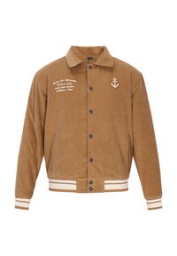 Bruine corduroy jas met een knoopsluiting aan de voorkant, twee zijzakken, witte geborduurde tekst en een ankerlogo. Voorzien van gestreepte ribboorden bij de mouwen en onderkant.