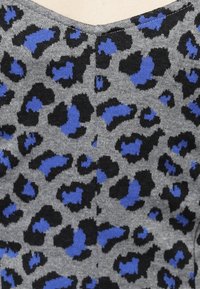 Tissu gris avec un motif léopard, agrémenté de touches de noir et de bleu. La texture semble douce et tricotée, avec une légère élasticité.