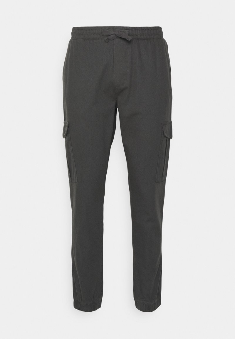 Tmavě šedé jogger kalhoty vyrobené z lehkého materiálu, s elastickým pasem na šňůrku a bočními cargo kapsami.
