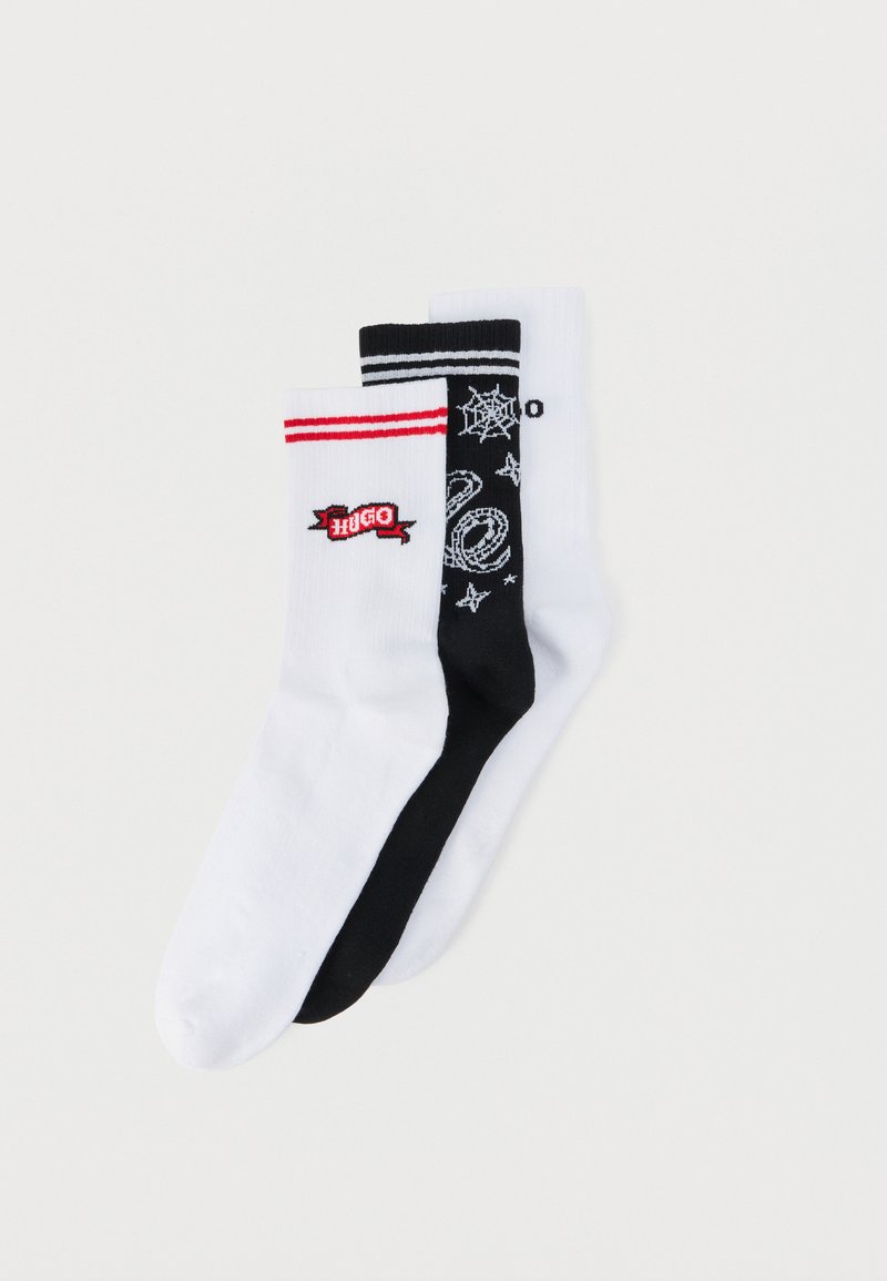 Τρία ζευγάρια κάλτσες πληρώματος: λευκές με κόκκινες ρίγες και λογότυπο "Hugo", μαύρες με λευκό σχέδιο αράχνης και αστέρια, και απλές λευκές.