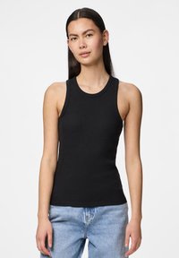 Černý žebrovaný top bez rukávů s kulatým výstřihem. Tkanina vypadá měkká a přiléhavá, kombinovaná s modrými džínami.