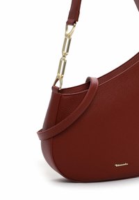 Bordeaux kleurige leren handtas met een textuur, een gebogen ontwerp, een slanke schouderriem en hardware in goudkleur. Voorzien van een discrete logo aan de voorkant.