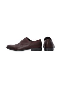 Braune lederne Schnürschuhe mit runder Zehenform, Schnürsenkeln und glatter Oberfläche. Mit einer flachen Gummisohle, die dezente Texturakzente aufweist.