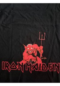 Černé bavlněné tričko s velkým červeným grafickým motivem rohaté bytosti držící trojzubec, s textem "IRON MAIDEN" v tučném červeném písmu pod ním.