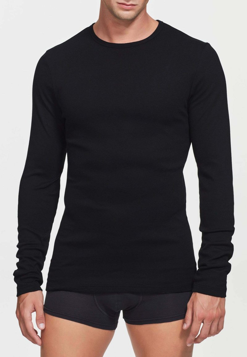T-shirt nero a maniche lunghe realizzato in tessuto morbido, con collo rotondo e design aderente, texture liscia e senza motivi o componenti visibili.