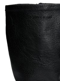 Botte en cuir noir avec une finition texturée, présentant un logo visible, une forme arrondie et des coutures minimales sur le bord supérieur.